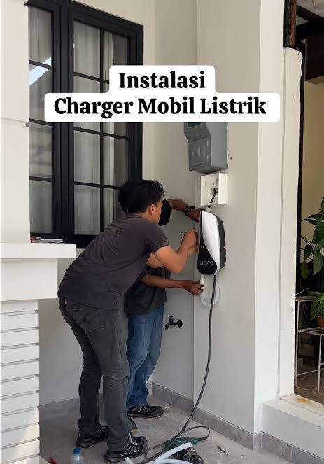 Teknisi wall charger EV profesional sedang bekerja